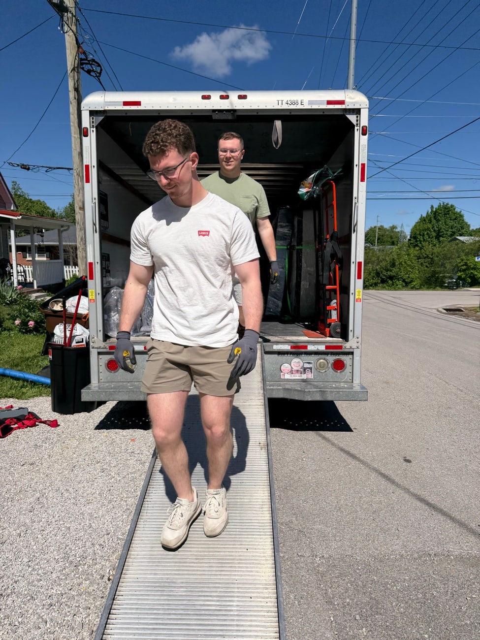 The New Creation Cleanup crew carrying a load down the box truck ramp.