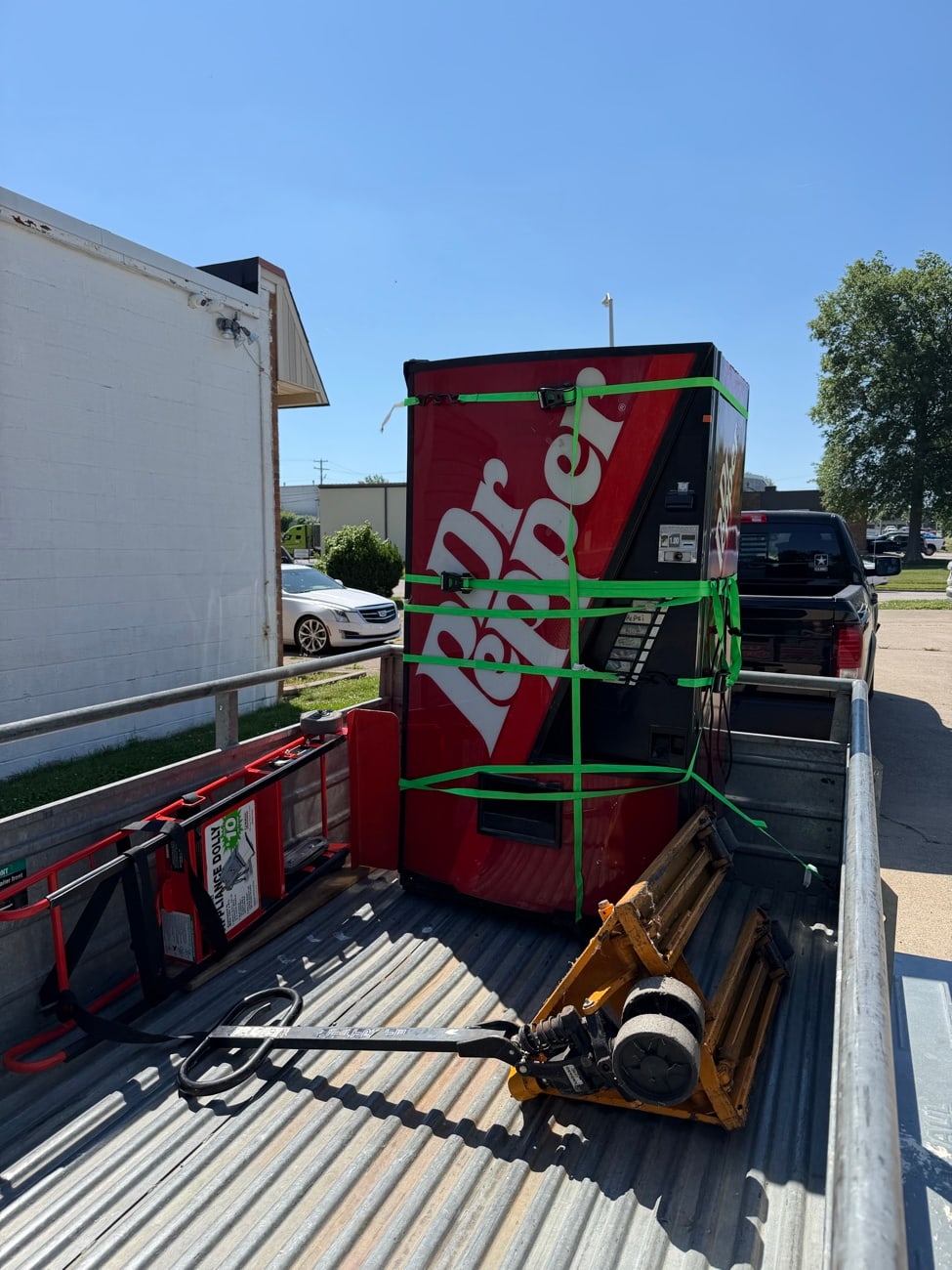 A full size vending machine strapped down on the truck for removal.